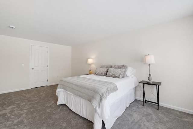 bedroom with dark carpet and baseboards