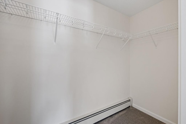 walk in closet featuring a baseboard heating unit and carpet flooring