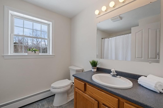 bathroom featuring toilet, vanity, and baseboard heating