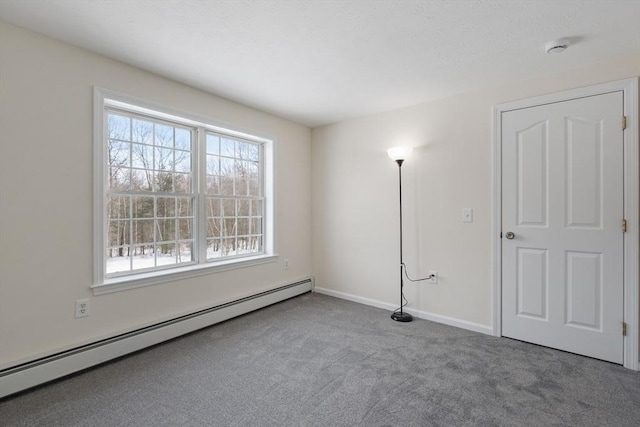 empty room with a baseboard radiator, baseboards, and carpet flooring