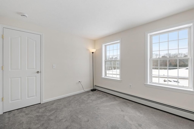 spare room with baseboards, light carpet, and baseboard heating