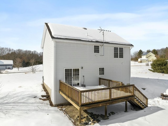 snow covered rear of property featuring a wooden deck