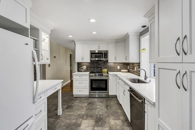 35 Wallace Rd, Wayland, MA 01778 - kitchen featuring light countertops, white cabinetry, a sink, backsplash, and stainless steel appliances