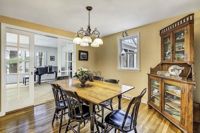 35 Wallace Rd, Wayland, MA 01778 - dining room featuring an inviting chandelier, baseboards, wood finished floors, and a healthy amount of sunlight