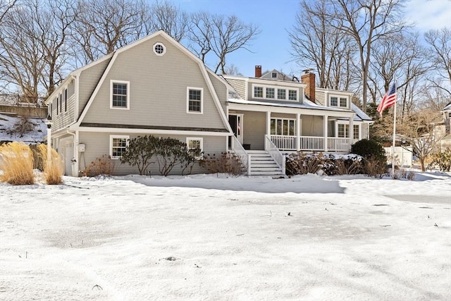 view of front of house with a porch and a gambrel roof