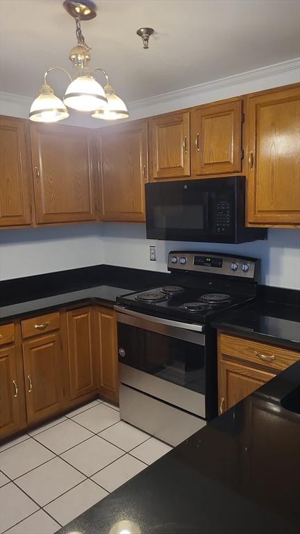 38 Carter St Unit 303, Everett, MA 02149 - kitchen featuring black microwave, stainless steel electric range oven, brown cabinets, dark countertops, and ornamental molding