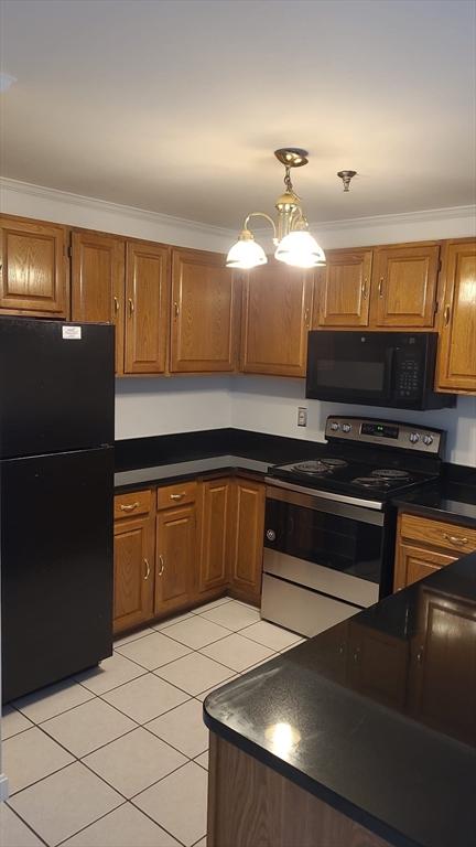 38 Carter St Unit 303, Everett, MA 02149 - kitchen with black appliances, dark countertops, light tile patterned floors, brown cabinets, and ornamental molding