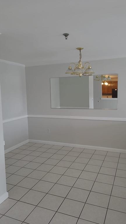 38 Carter St Unit 303, Everett, MA 02149 - empty room with a chandelier, light tile patterned floors, and crown molding