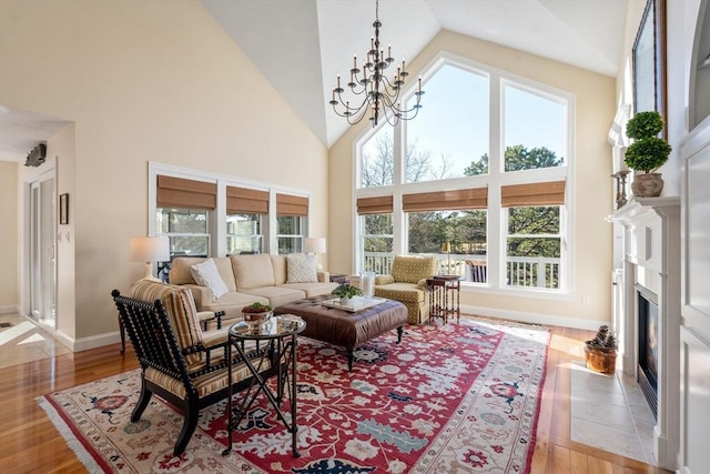 living room with a chandelier, light hardwood / wood-style flooring, and high vaulted ceiling