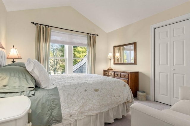 carpeted bedroom with a closet and lofted ceiling