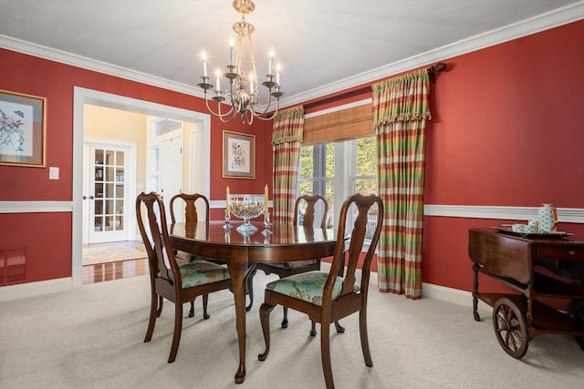 carpeted dining area featuring crown molding and a notable chandelier