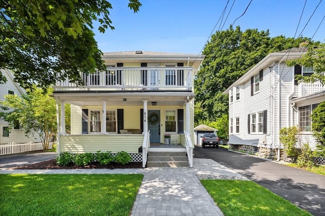 614 Summer St, Arlington, MA 02474 - view of front of house with a porch, a balcony, driveway, and a front lawn
