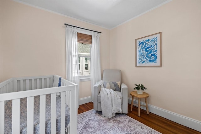 614 Summer St, Arlington, MA 02474 - bedroom featuring wood finished floors, crown molding, and a nursery area