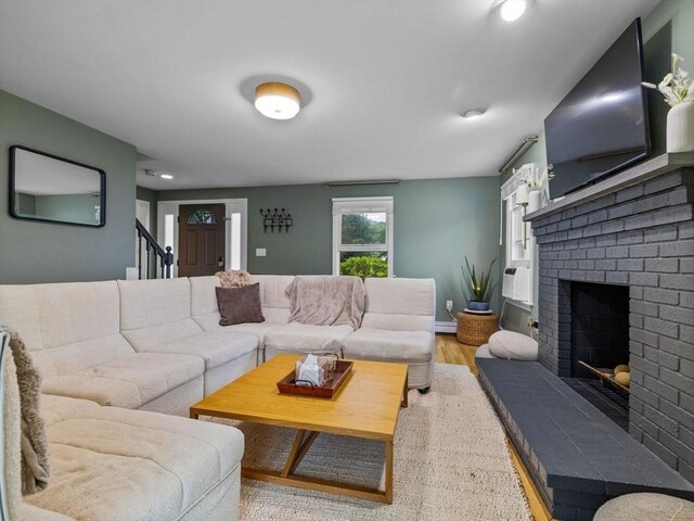 168 Maple St, Boston, MA 02132 - living area featuring a fireplace, wood finished floors, a baseboard heating unit, and stairway