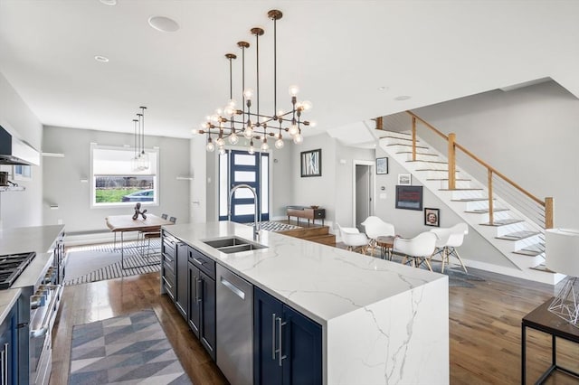 kitchen featuring a sink, blue cabinets, dark wood-style floors, and stainless steel appliances