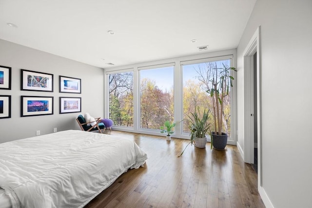 bedroom featuring visible vents, baseboards, and hardwood / wood-style floors