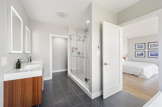 ensuite bathroom featuring vanity, baseboards, a stall shower, and connected bathroom