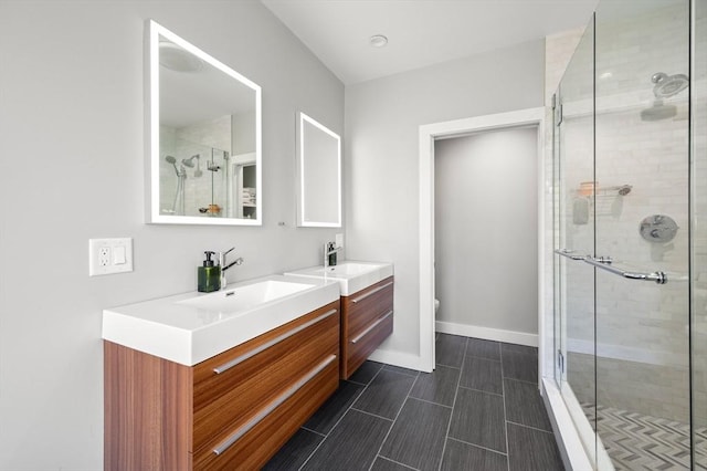 bathroom with vanity, toilet, baseboards, and a stall shower