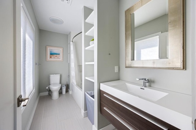 bathroom with vanity, baseboards, toilet, and shower / tub combo
