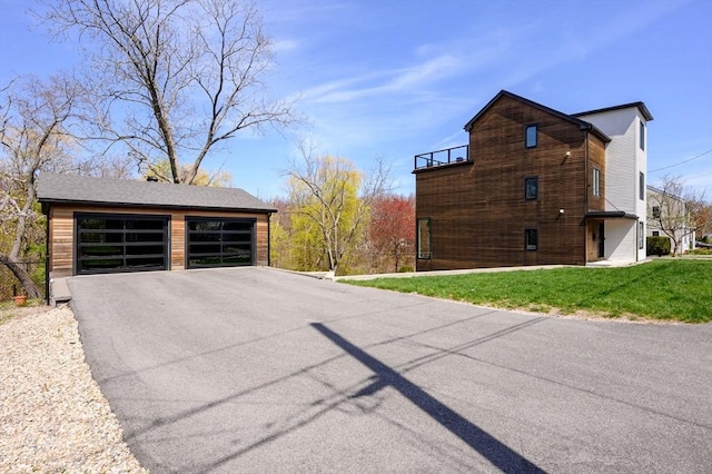view of home's exterior featuring a garage, a yard, and driveway