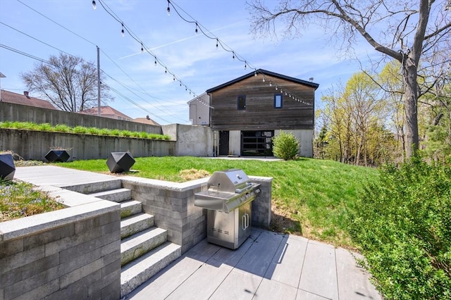 back of house featuring fence, a lawn, and area for grilling