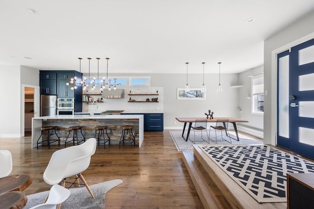 interior space with baseboards, a wealth of natural light, and dark wood-style floors