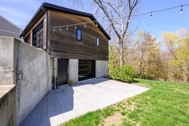 exterior space with a patio, a front lawn, and a detached garage