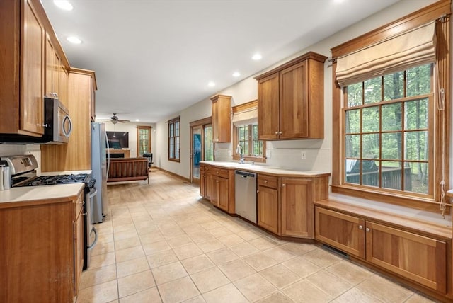 kitchen featuring a ceiling fan, a sink, appliances with stainless steel finishes, light tile patterned flooring, and recessed lighting