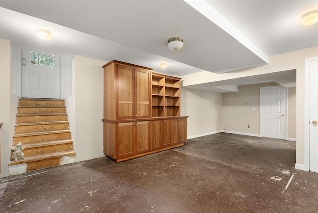 finished basement featuring stairway and baseboards