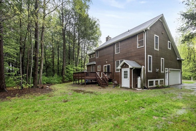 rear view of house featuring a lawn, a garage, a chimney, and a deck
