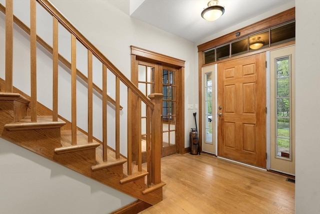 entrance foyer with stairs and light wood-style floors
