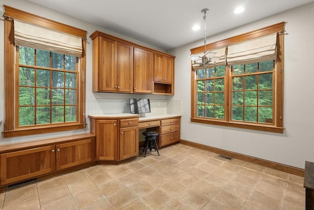 office space featuring baseboards, built in desk, and recessed lighting