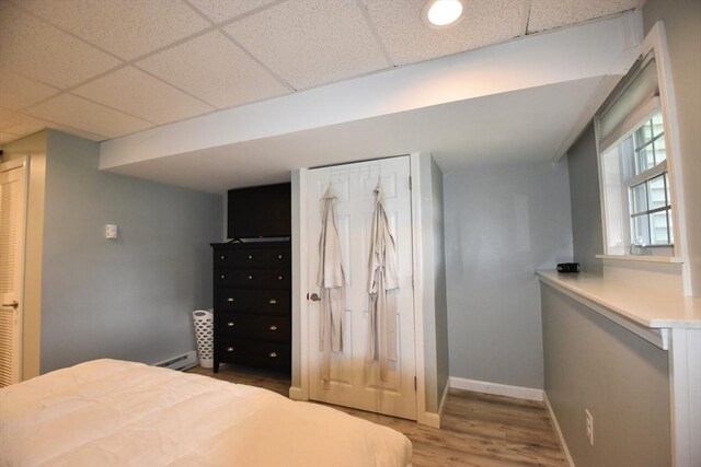 251 Sunderland Rd Unit 251, Worcester, MA 01604 - bedroom featuring baseboard heating, wood finished floors, and a drop ceiling