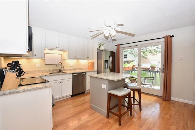251 Sunderland Rd Unit 251, Worcester, MA 01604 - kitchen with stainless steel appliances, white cabinets, ceiling fan, a kitchen breakfast bar, and a center island