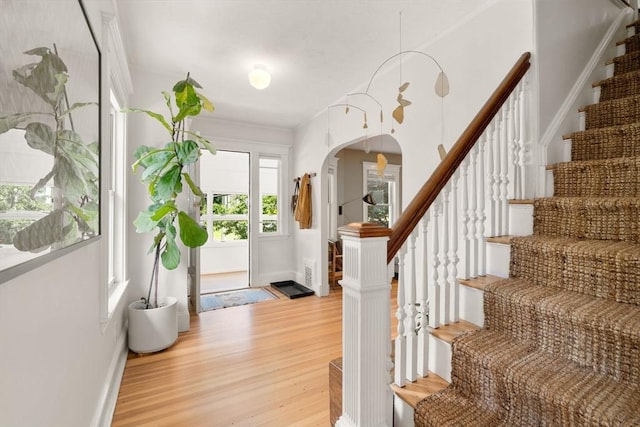 68 Cliftondale St, Boston, MA 02131 - entryway featuring light wood-style floors, arched walkways, stairway, and baseboards