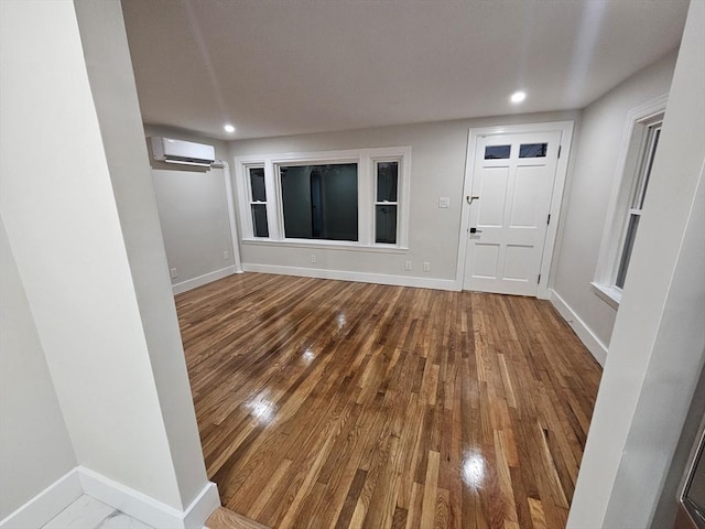 foyer featuring hardwood / wood-style floors and a wall unit AC