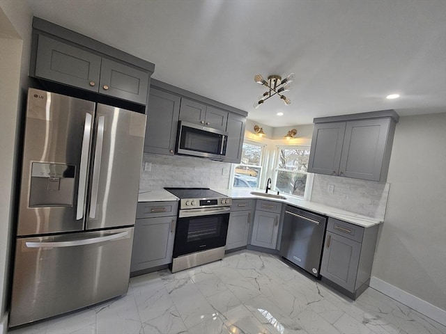 kitchen with tasteful backsplash, sink, gray cabinets, and stainless steel appliances