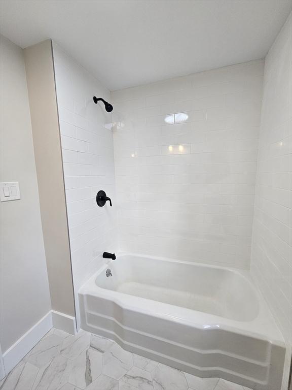 bathroom featuring tiled shower / bath