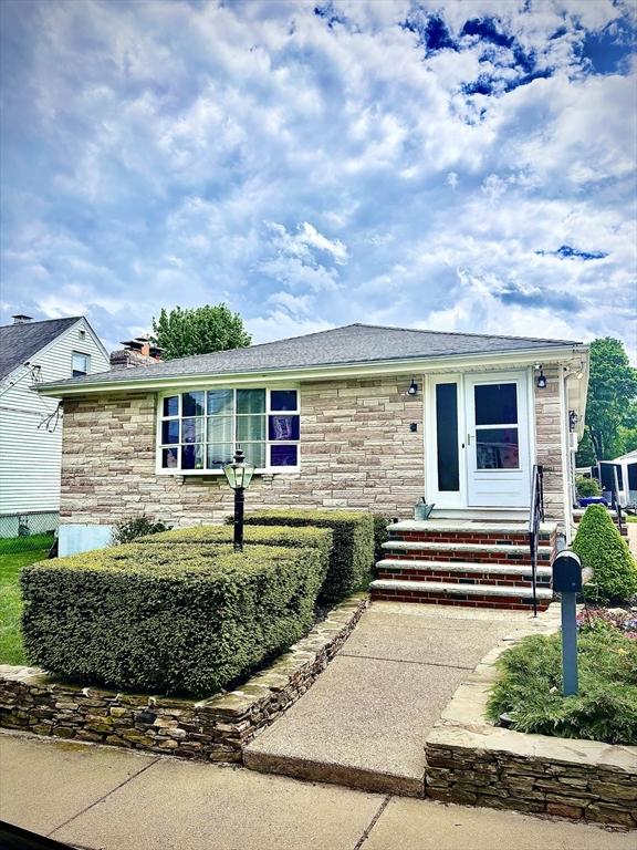 view of front of home featuring stone siding and a chimney