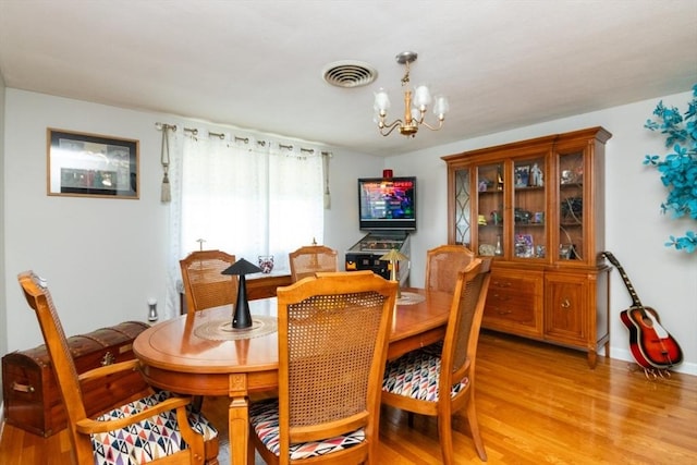 dining area with a chandelier and light wood finished floors