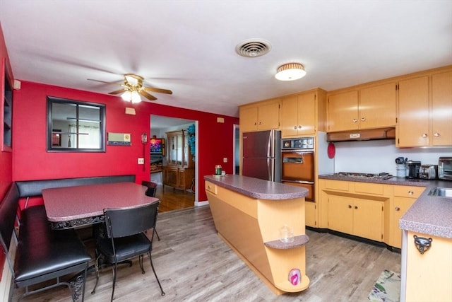 kitchen featuring appliances with stainless steel finishes, light wood-style flooring, dark countertops, and ceiling fan