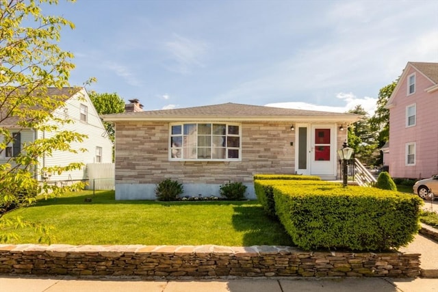 view of front of property featuring a front yard, stone siding, and a chimney