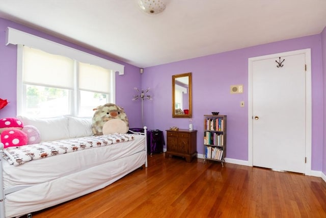 bedroom with hardwood / wood-style flooring and baseboards