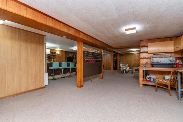 finished below grade area featuring wooden walls and carpet floors
