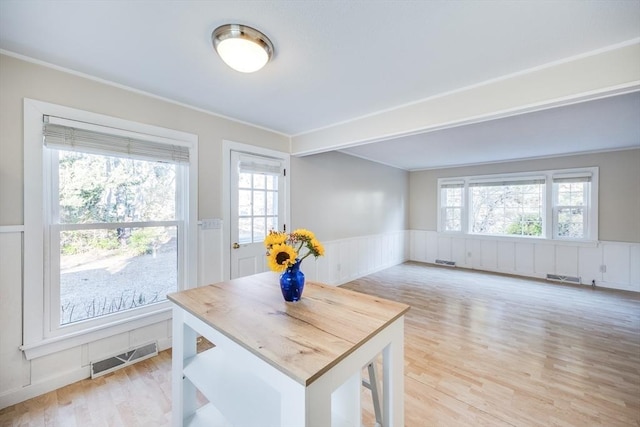 dining space featuring light wood-type flooring and crown molding