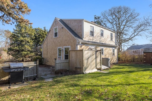 rear view of property with a lawn and central AC unit