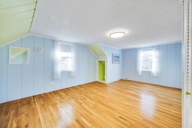 additional living space featuring light hardwood / wood-style floors and vaulted ceiling