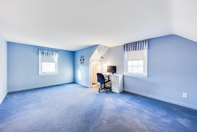 unfurnished office featuring carpet floors and vaulted ceiling