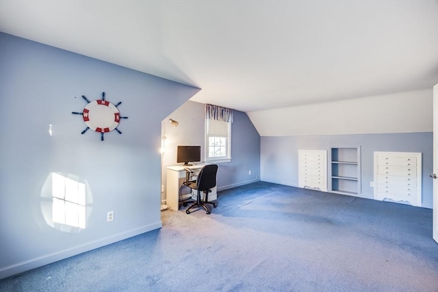 office with built in features, carpet, and vaulted ceiling