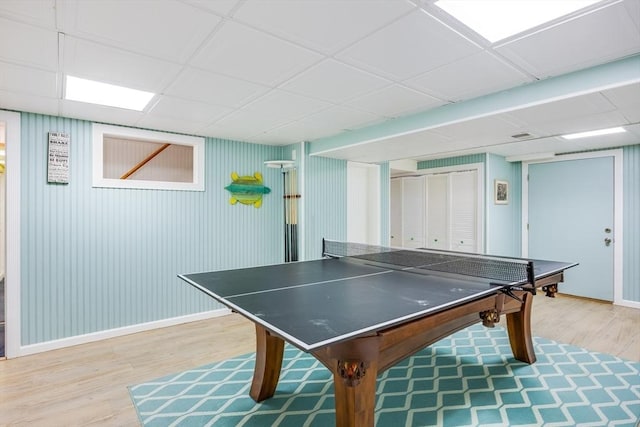 game room with hardwood / wood-style floors and a paneled ceiling